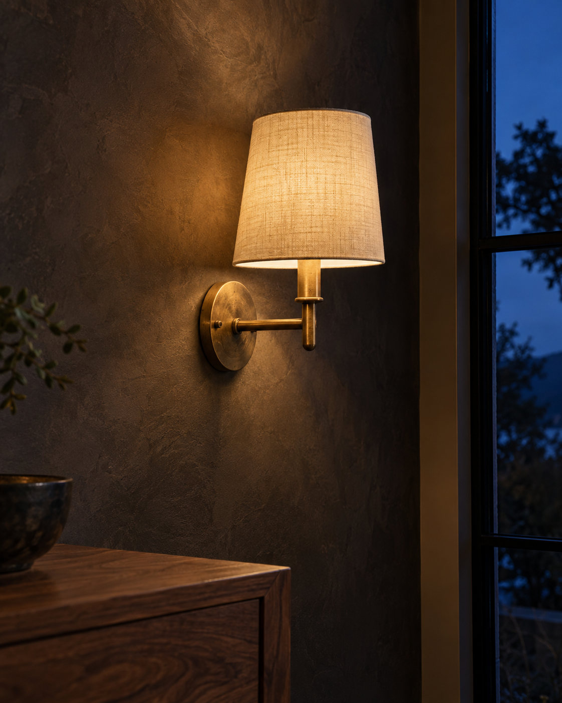 A brass wall sconce, lit